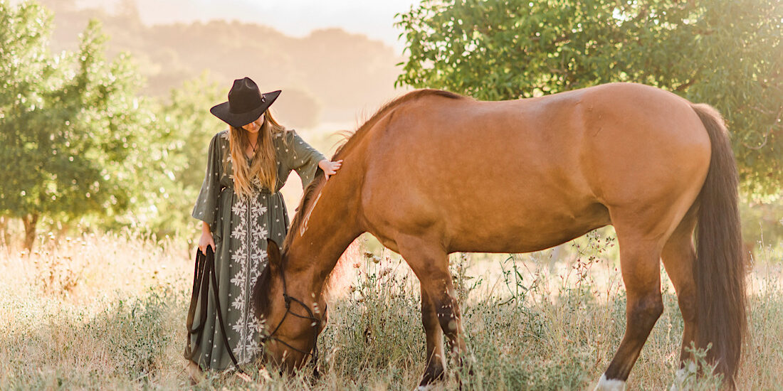 Beautiful picture of owner with horse, Mikko in a field eating some grass.