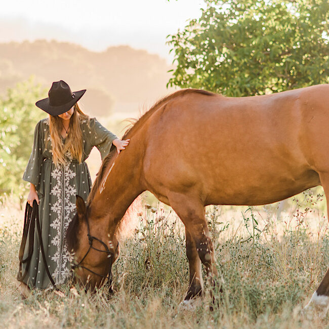 Beautiful picture of owner with horse, Mikko in a field eating some grass.